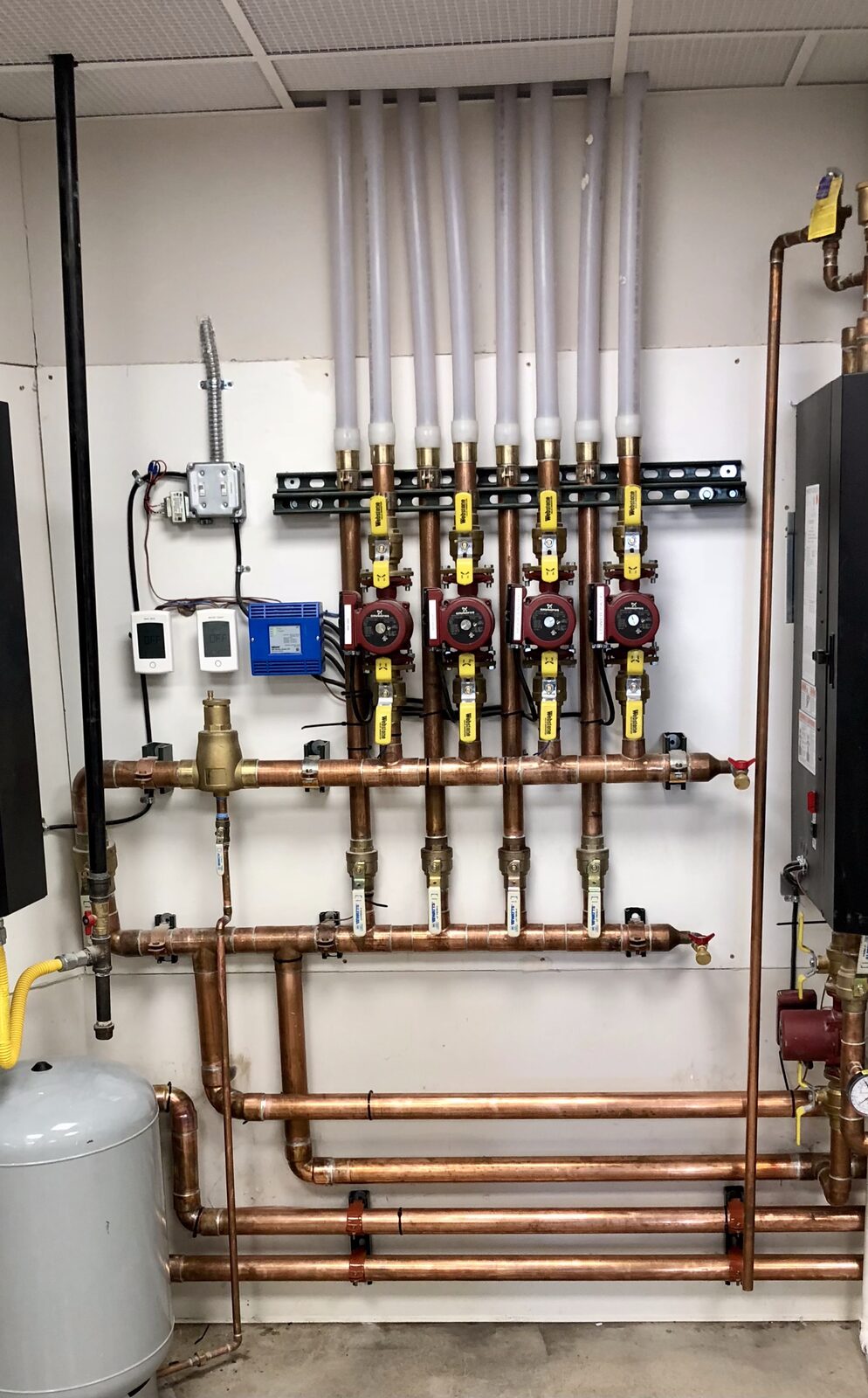 Twin high-efficiency condensing boilers installed and piped in a mechanical room