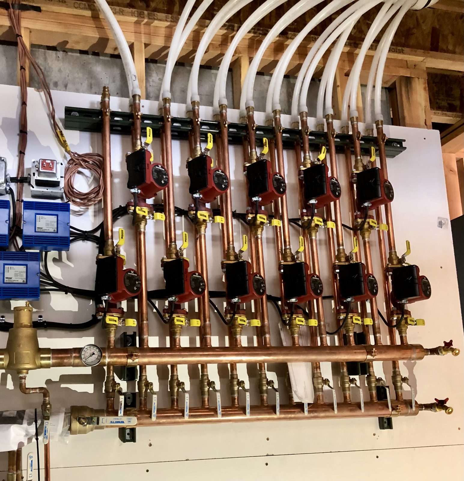 Multi-zone radiant heating manifold distributing warm water to floor loops